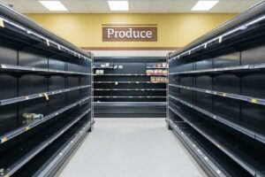 Empty grocery store produce shelves due to supply chain delays”